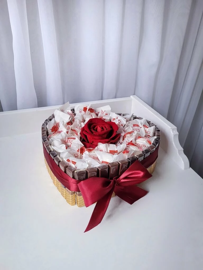 flower box z różą i słodyczami rafaello, główne zdjęcie produktu w kształcie serca wykonanego z czekoladek merci oraz wypełnionego rafaello z wieczną różą na środku